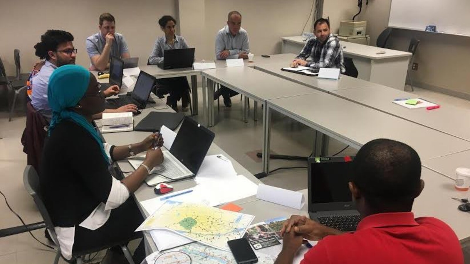 Des étudiants et des entrepreneurs sont assis sur des chaises, devant des tables de travail, à l’intérieur d’une salle de classe. Les étudiants prennent des notes à l’aide d’un ordinateur portable.