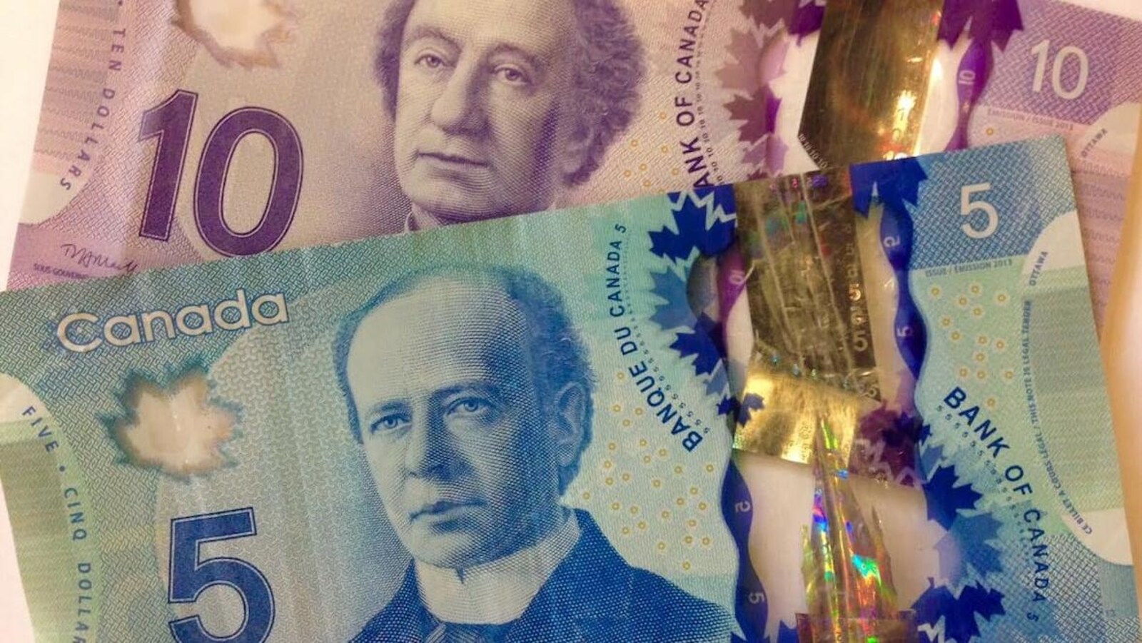 Un billet de cinq dollars sur un billet de dix dollars.