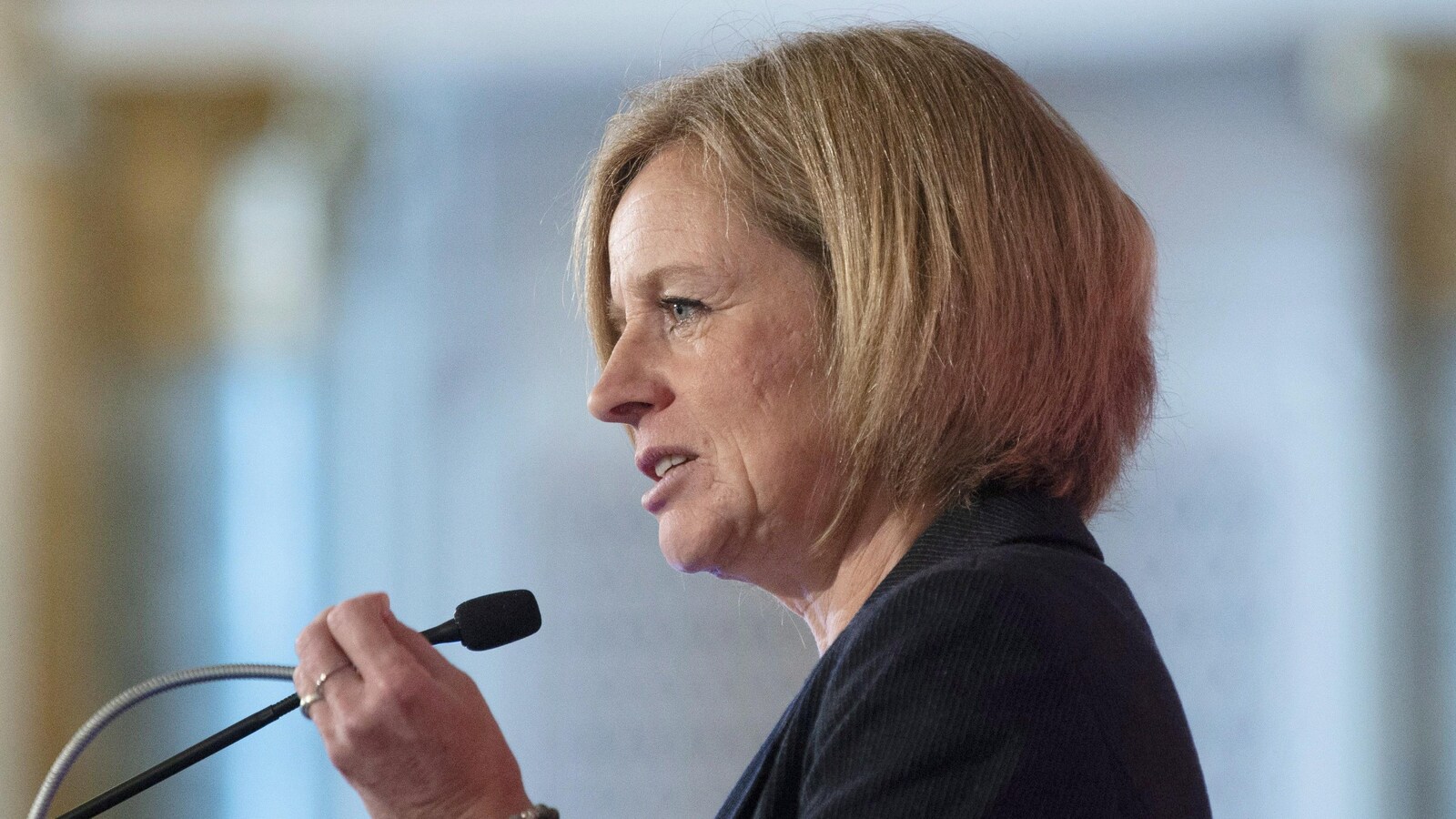 La première ministre de l'Alberta, Rachel Notley, est debout devant un micro et lève la main gauche lors d'un discours à Ottawa.