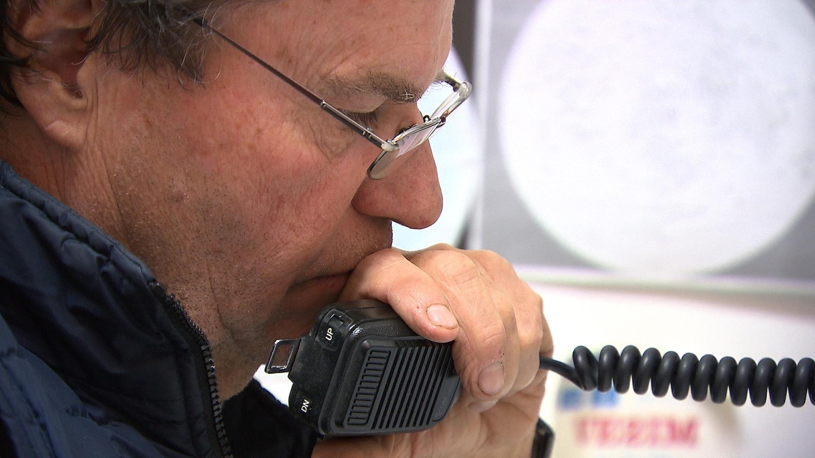 Un homme tient un micro de radio amateur.