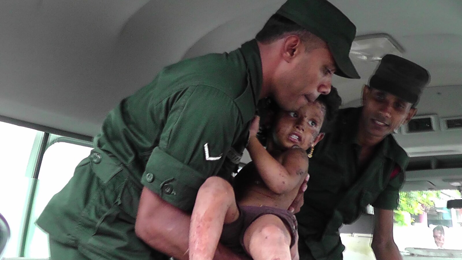 Des soldats aident un enfant blessé