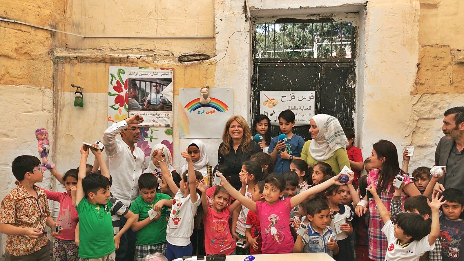 Les enfants réfugiés syriens lèvent les bras de joie après avoir reçu leurs radios.