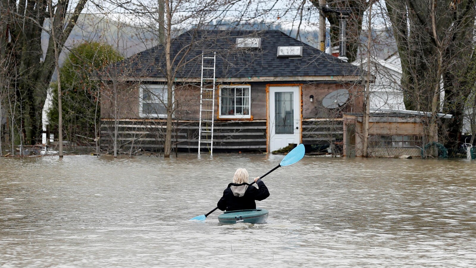 Une dame se rend à la rame jusqu'à une maison à Rigaud.