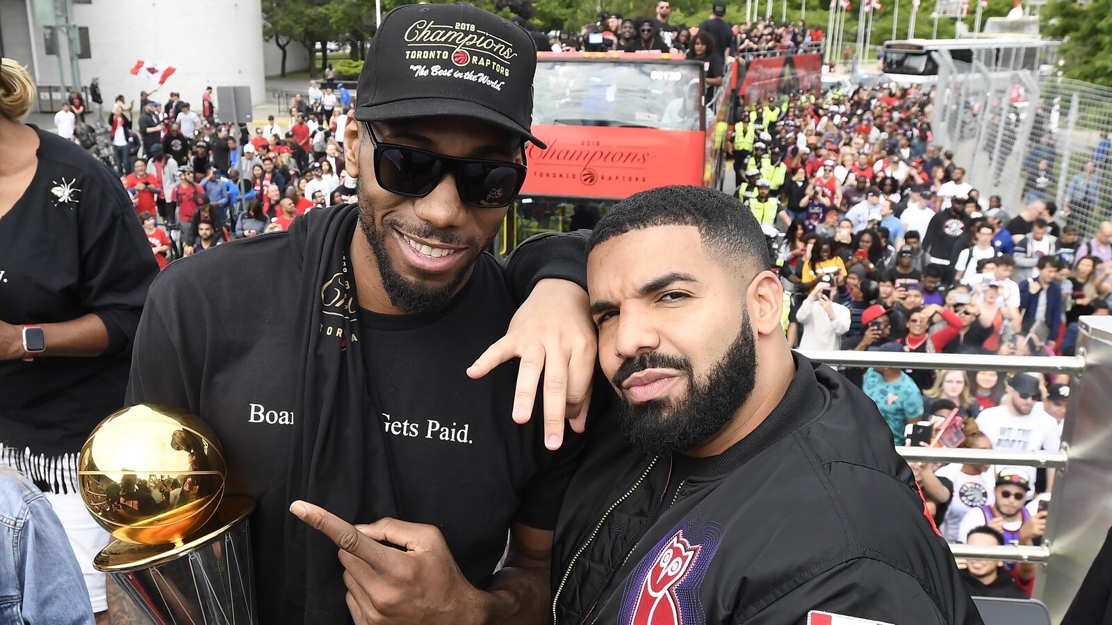 Kawhi Leonard tenant le trophée de la NBA, pose en compagnie de Drake.