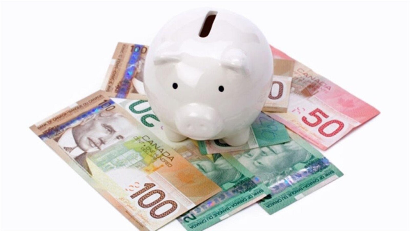 Une tirelire en forme de cochon posée sur des billets de banque