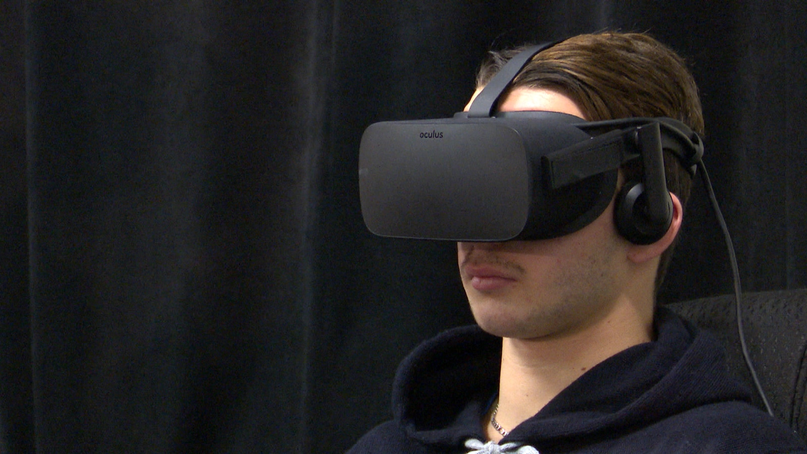 Un jeune homme a un casque de réalité virtuelle sur la tête.