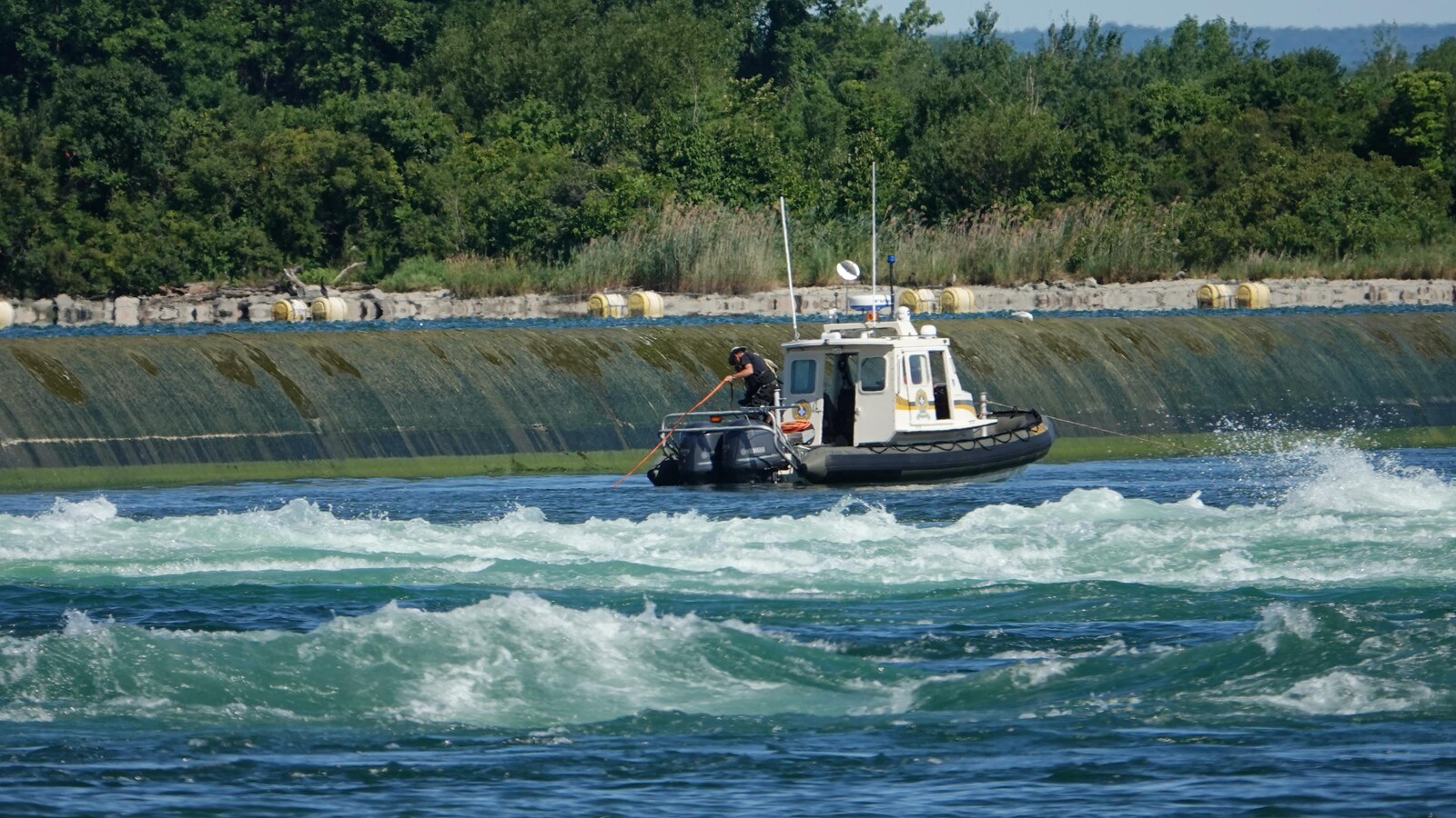 Un policier manie une gaffe depuis un bateau.