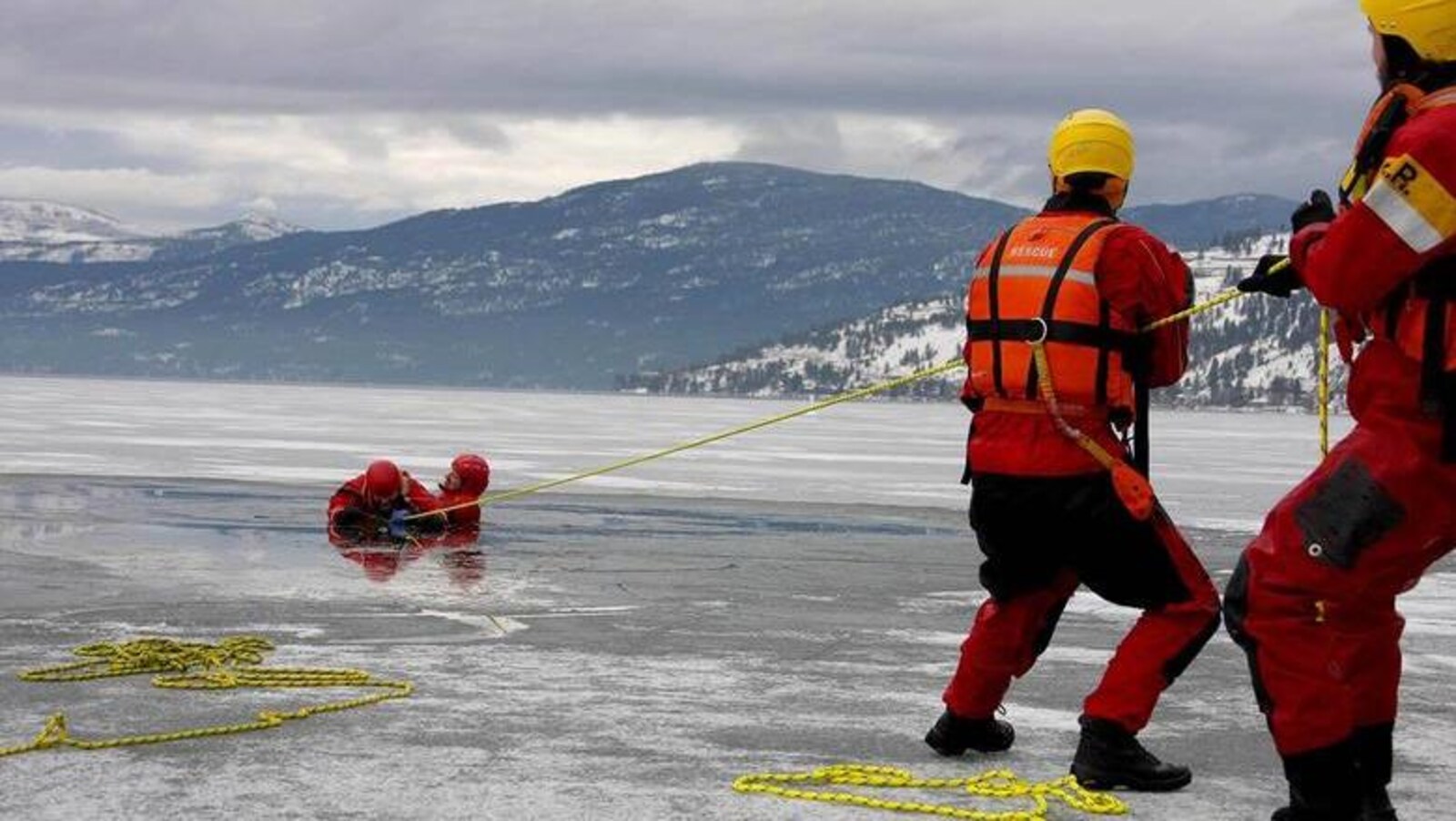 Des sauveteurs repêchent une personne d'un lac glacé.