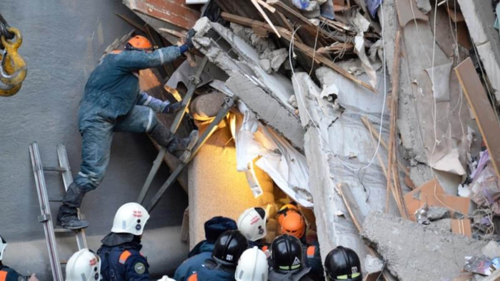 L'équipe de secours, dont un dans une échelle, à travers des débris.