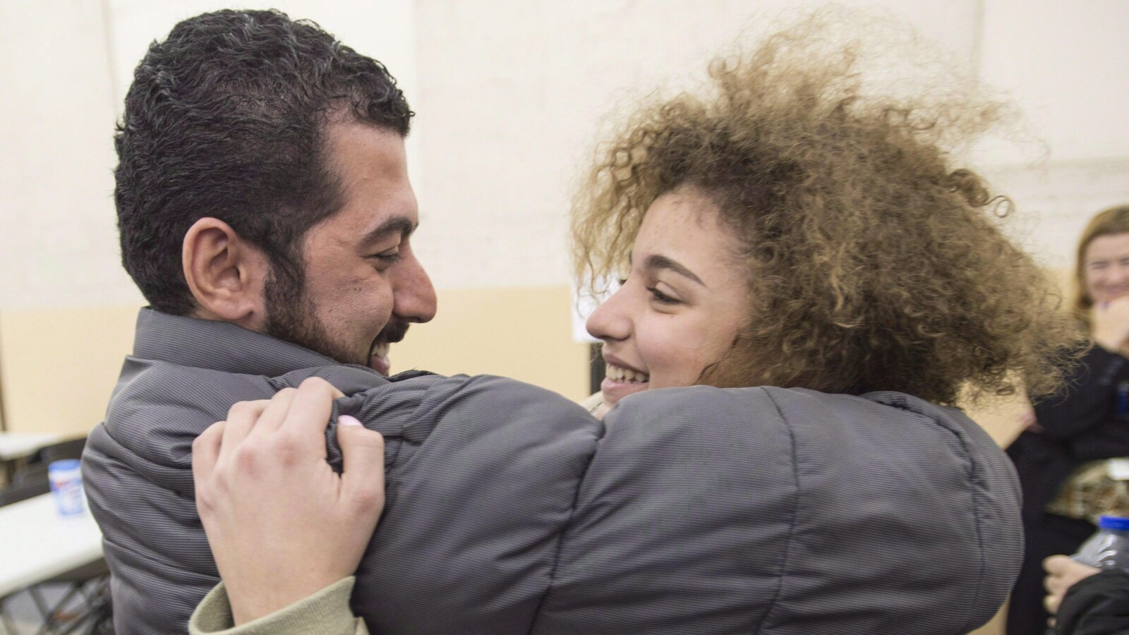Anas Francis, oncle de la réfugiée syrienne Layla Beylouneh, nouvellement arrivée, la prend dans ses bras alors qu'ils sont de nouveau réunis, dans un centre d'accueil de Montréal, le 12 décembre 2015.