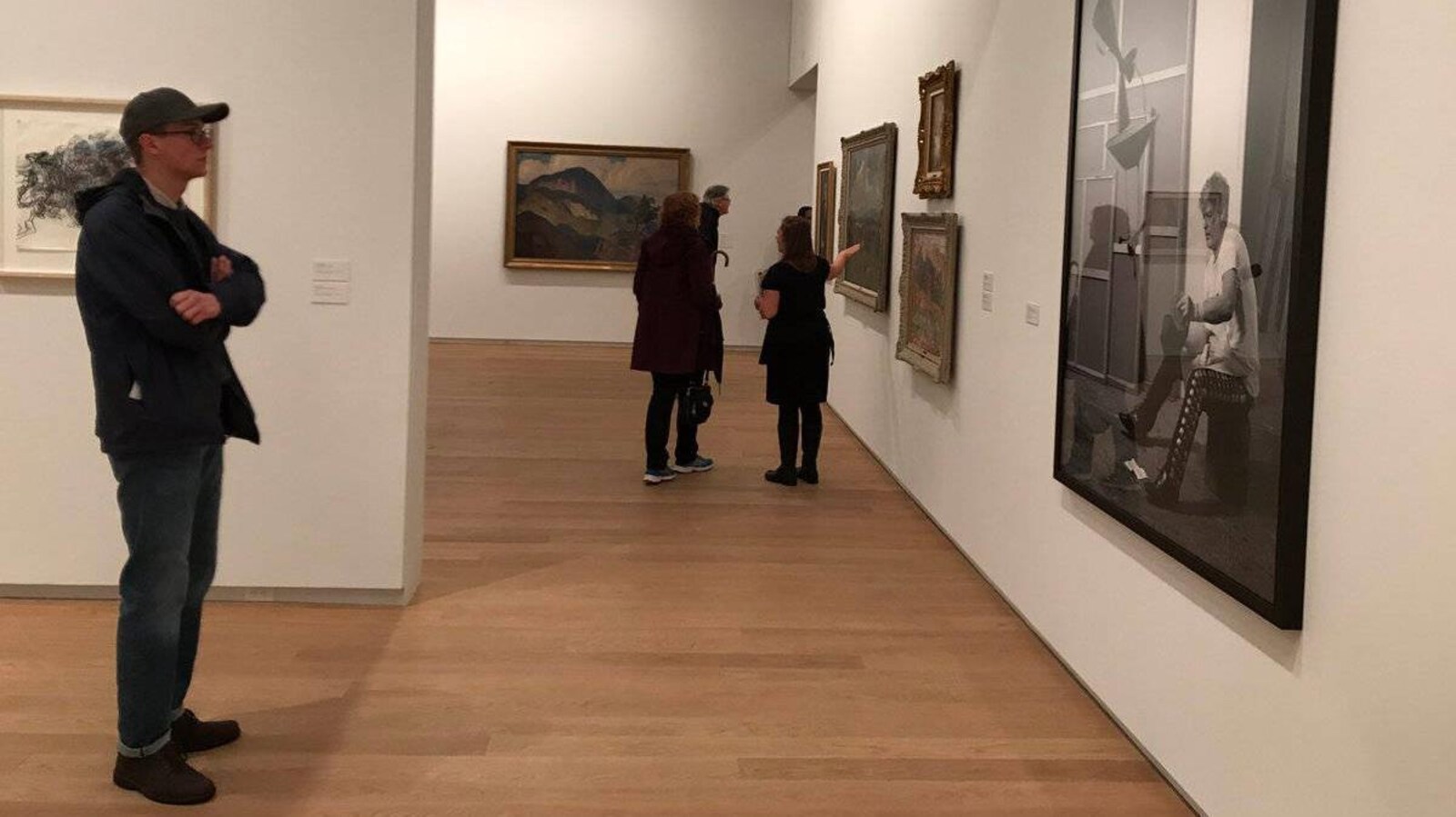 Un homme portant une casquette regarde un tableau dans une salle du Musée d'art moderne Remai à Saskatoon