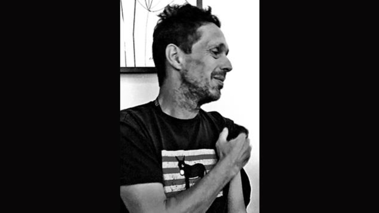 Portrait en noir et blanc du poète Rémi Tremblay, de profil, un bras croisé devant la poitrine.