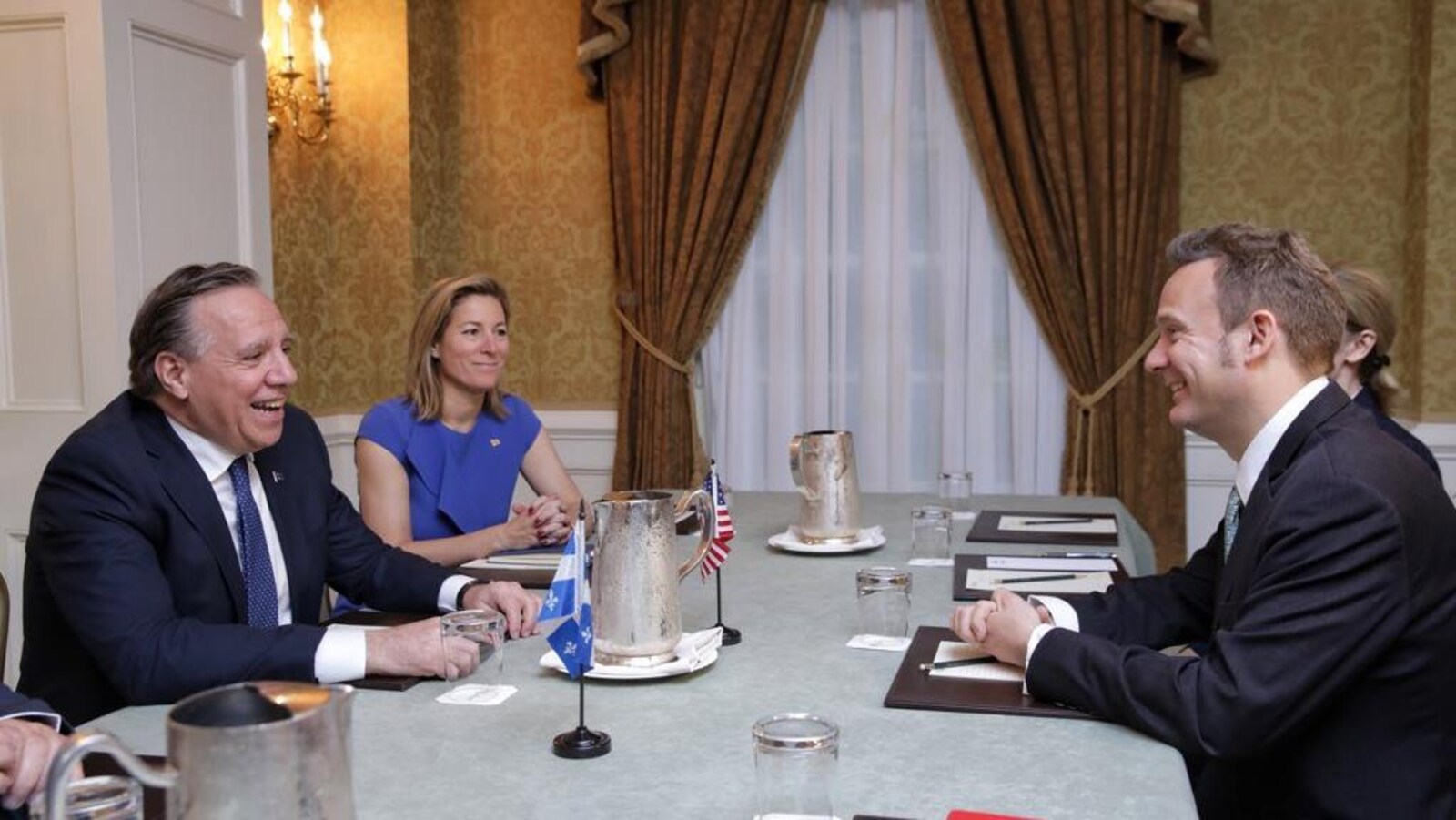 Deux hommes et deux femmes sont assis autour d'une table.