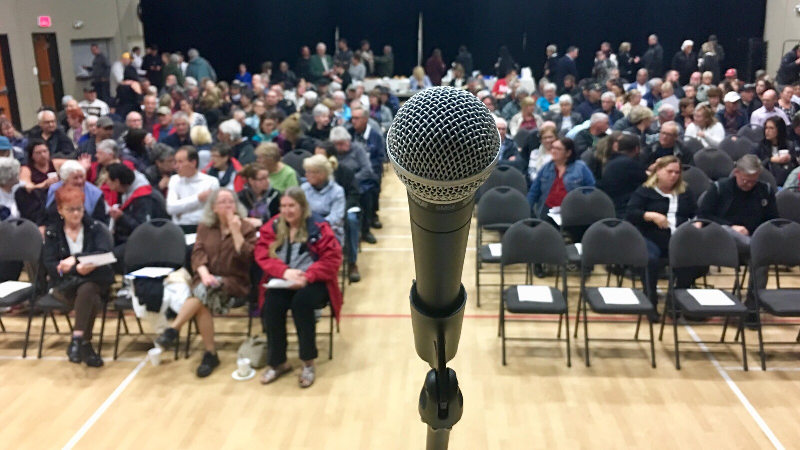 Les résidents sont assis dans le gymnase, en attendant le début de la rencontre.