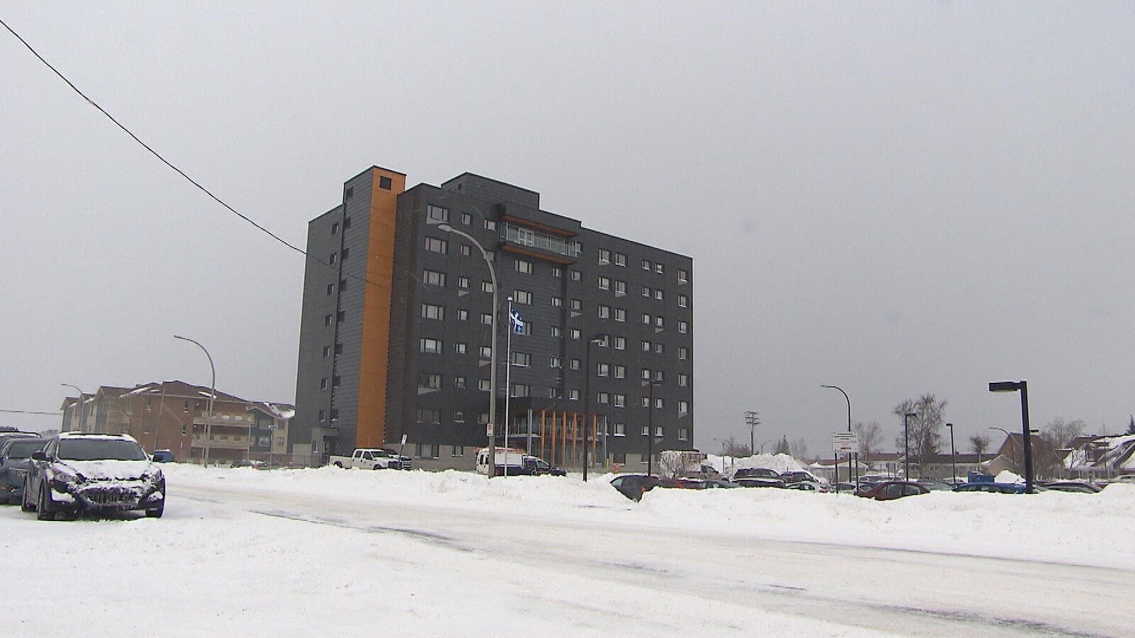 Une grande résidence de plusieurs étages dans une ville enneigée.