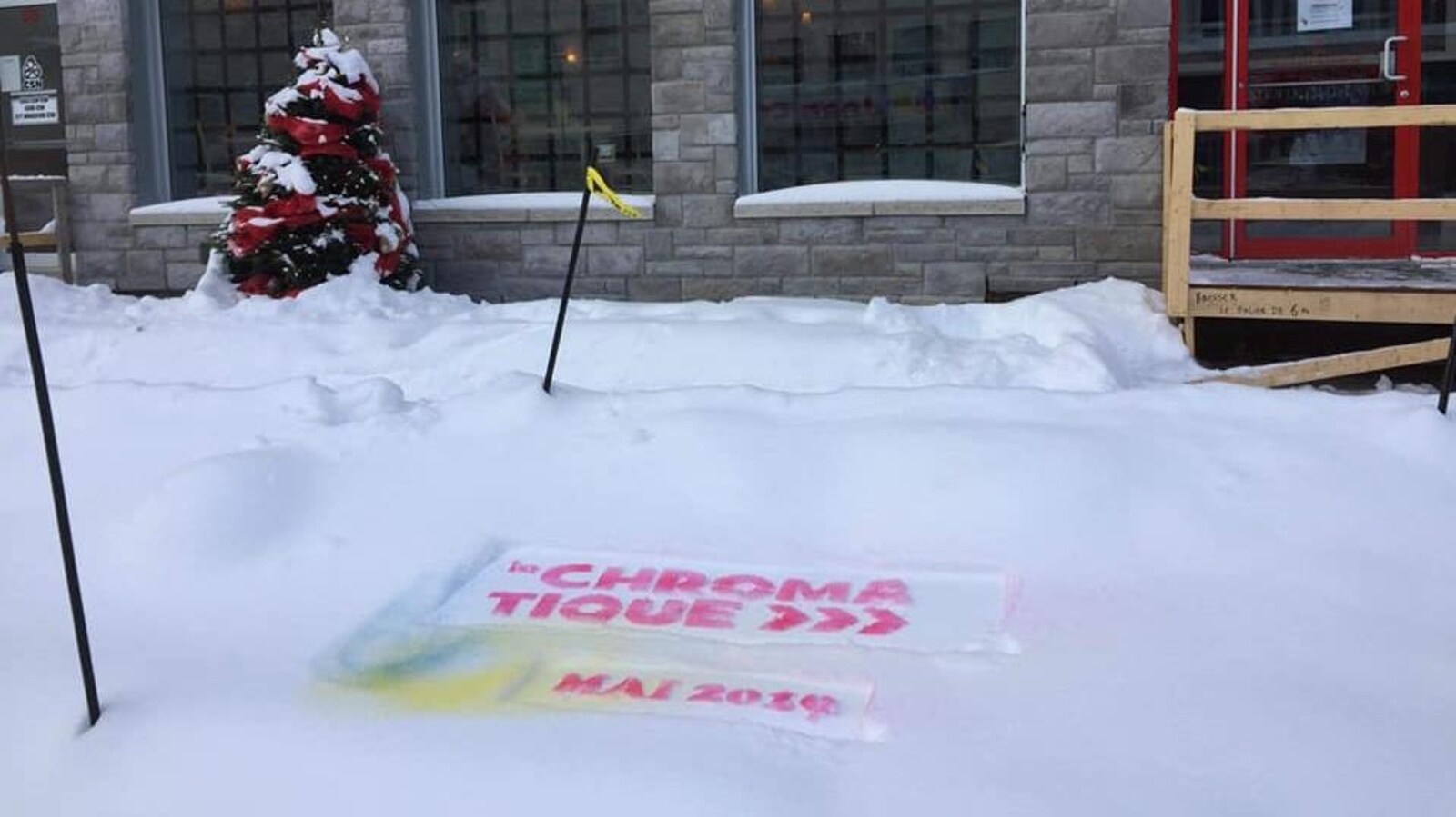 Un logo de la Chromatique avec la date mai 2019 est dessiné dans la neige devant un restaurant.