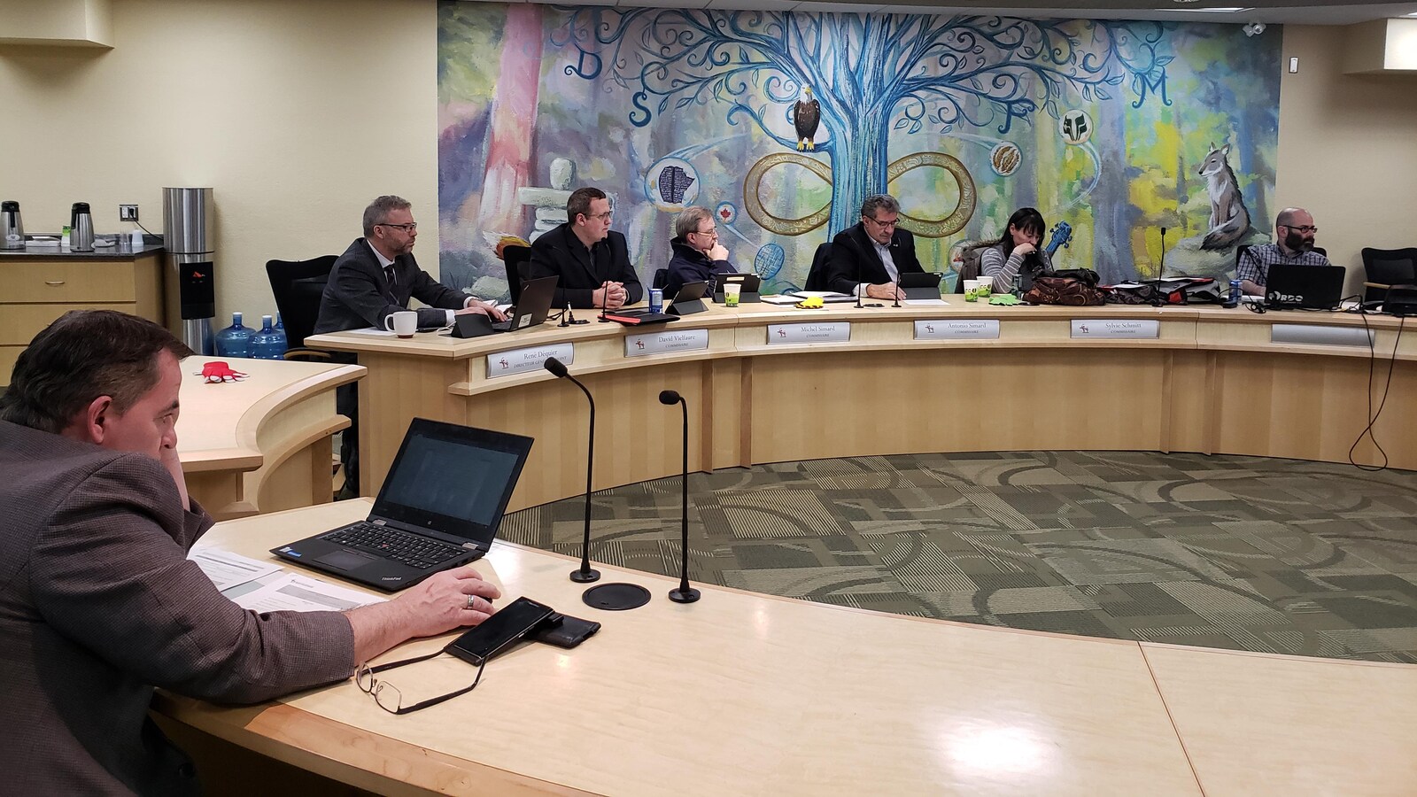Des participants assis à leurs bureaux pendant une rencontre.