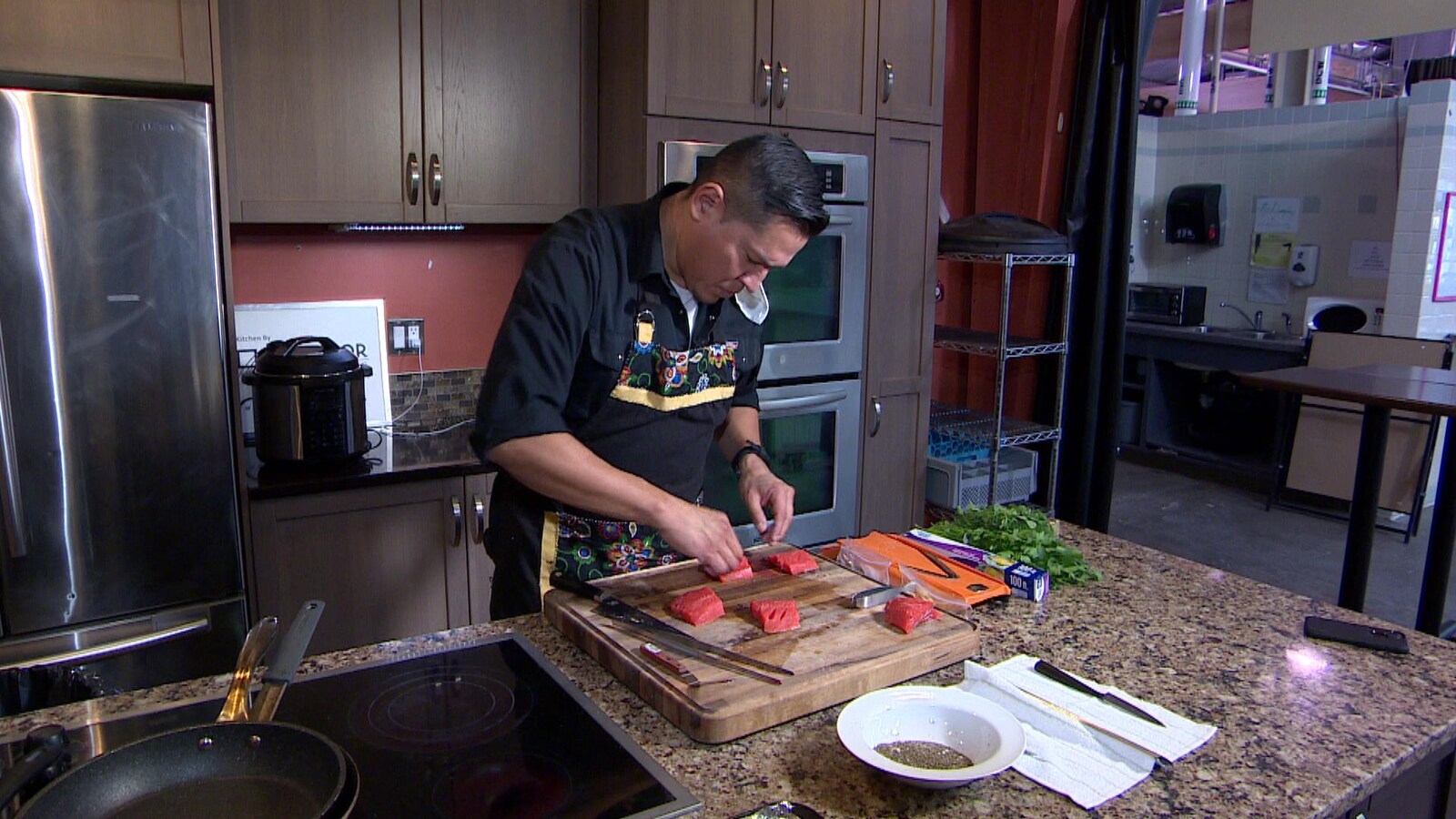 Le chef autochtone Rich Francis prépare un plat de saumon dans sa cuisine.