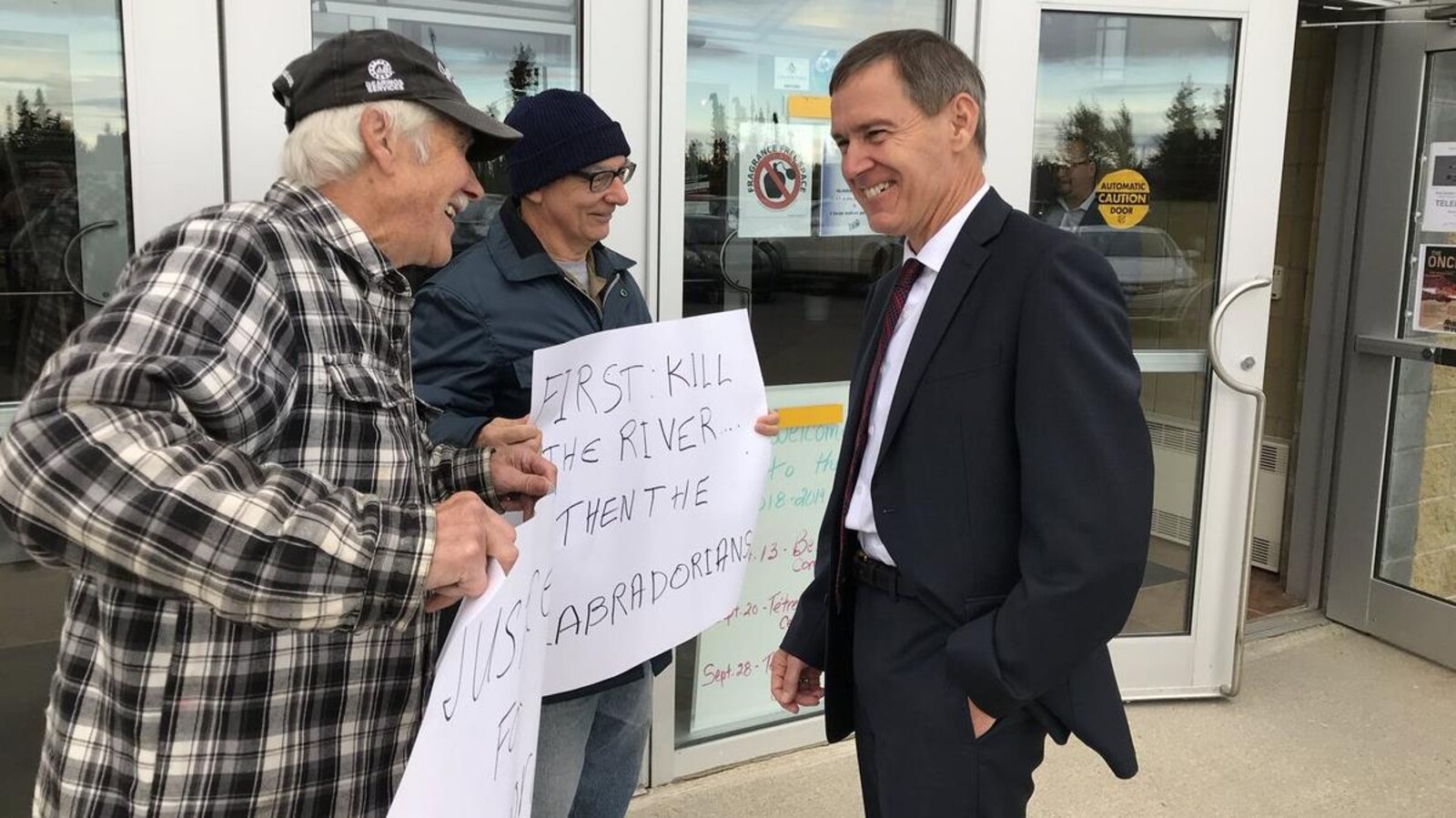 Le juge Richard LeBlanc converse avec deux manifestants devant le Centre Lawrence O'Brien, le 17 septembre 2018 à Happy Valley-Goose Bay, au Labrador.