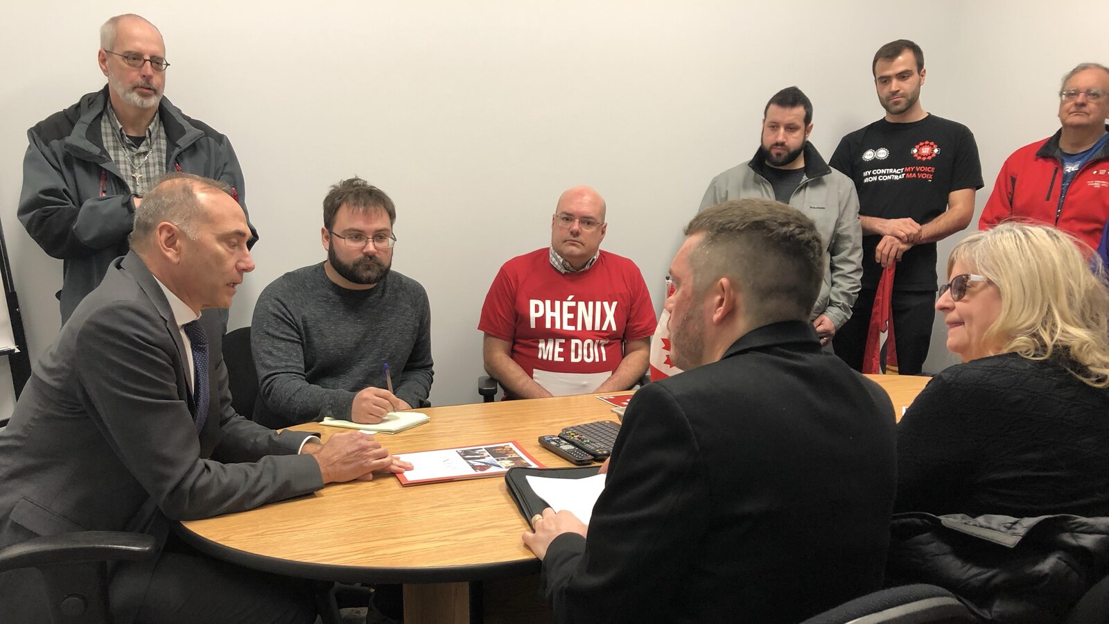 Des membres du syndicat AFPC sont assis autour d'une table avec Richard Martel.