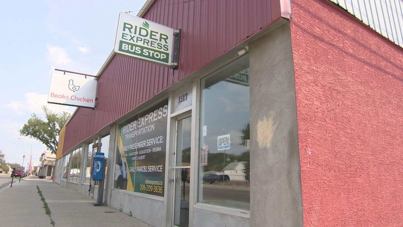 Les bureaux extérieurs de l'entreprise de Regina Rider Express Transportation. On y voit une affiche dans la vitrine indiquant un trajet par jour pour les passagers qui voyagent entre Saskatoon, Regina et Prince Albert.