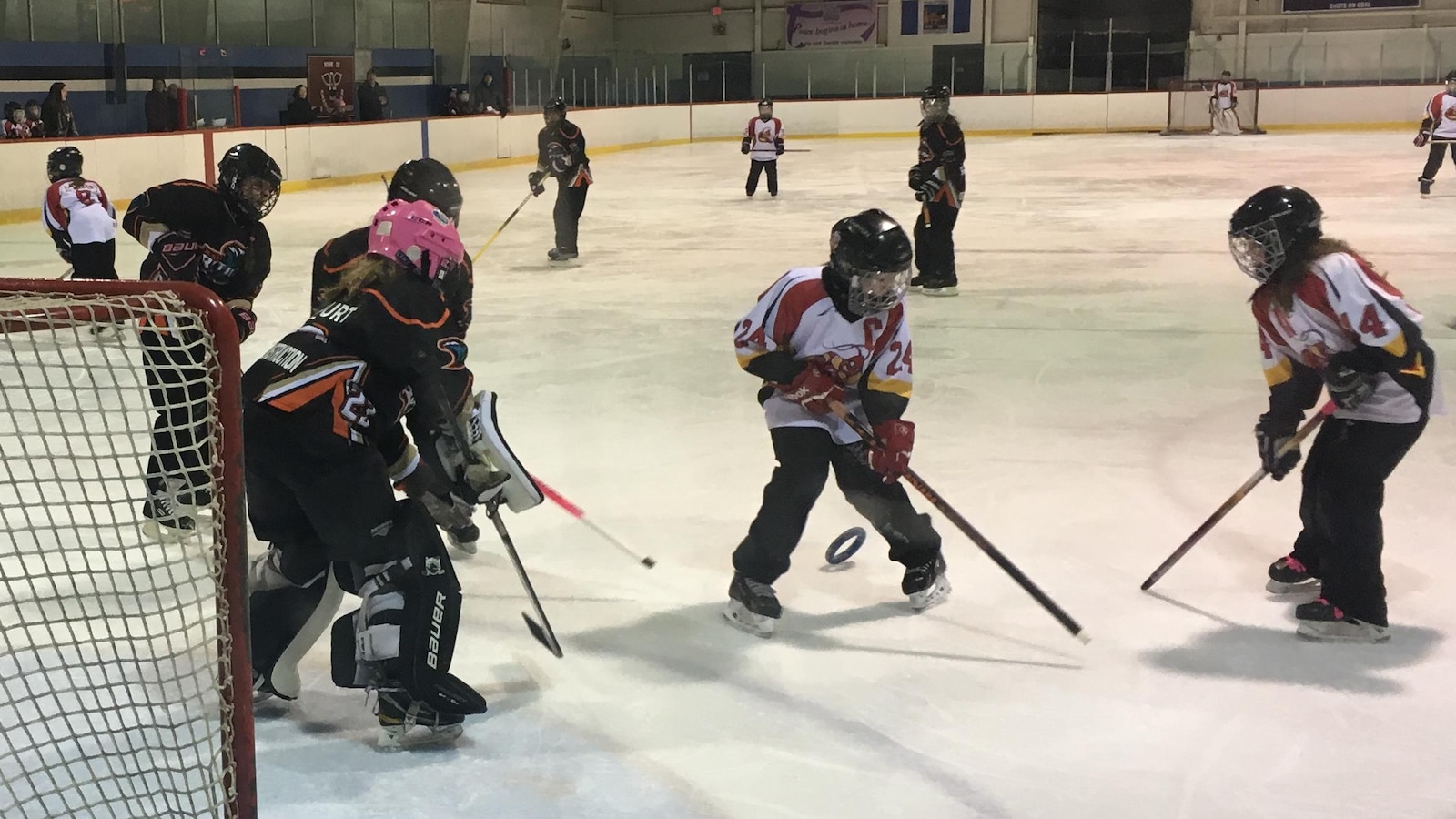 De jeunes filles sur la glace en train de jouer à la ringuette.
