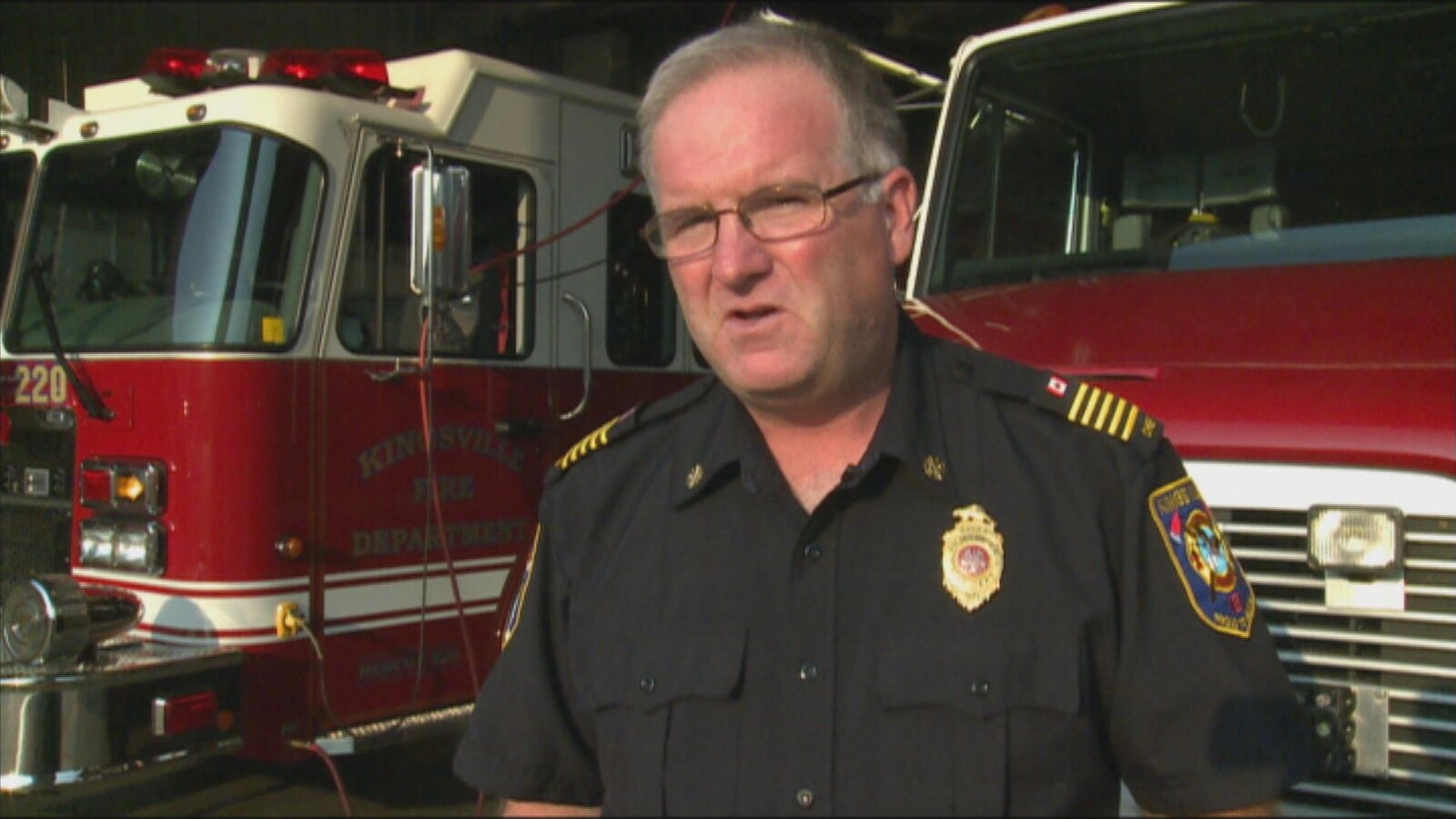 Robert Kissner devant des camions de pompiers.