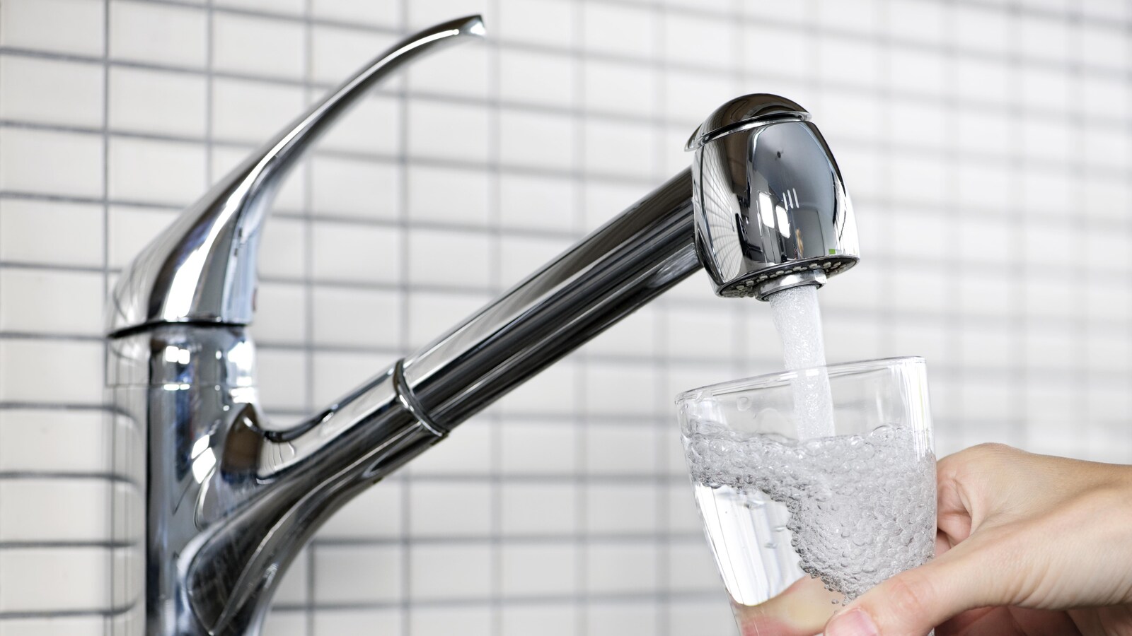 Un verre est rempli avec l'eau du robinet.