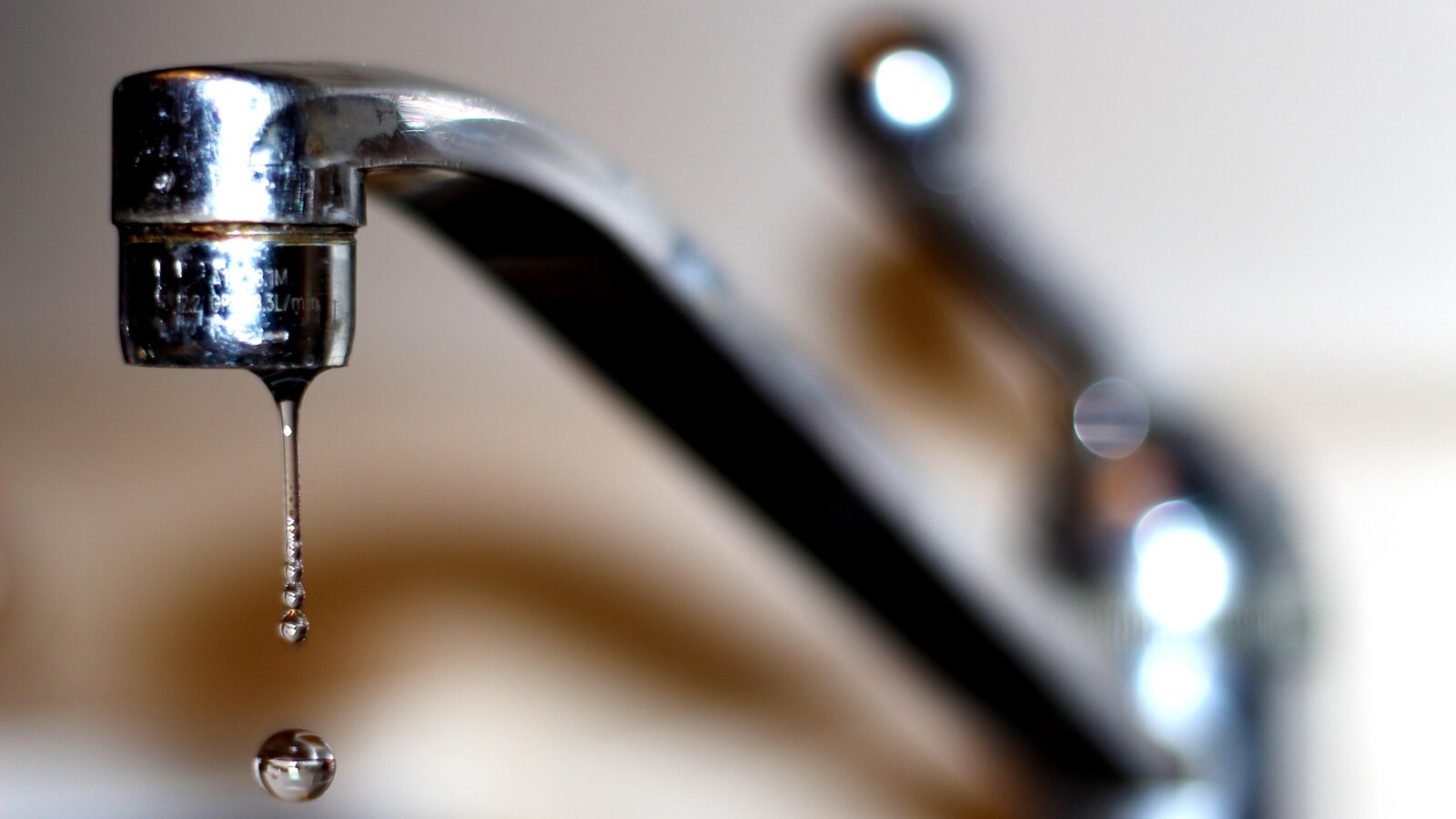 Un filet d'eau coule d'un robinet.