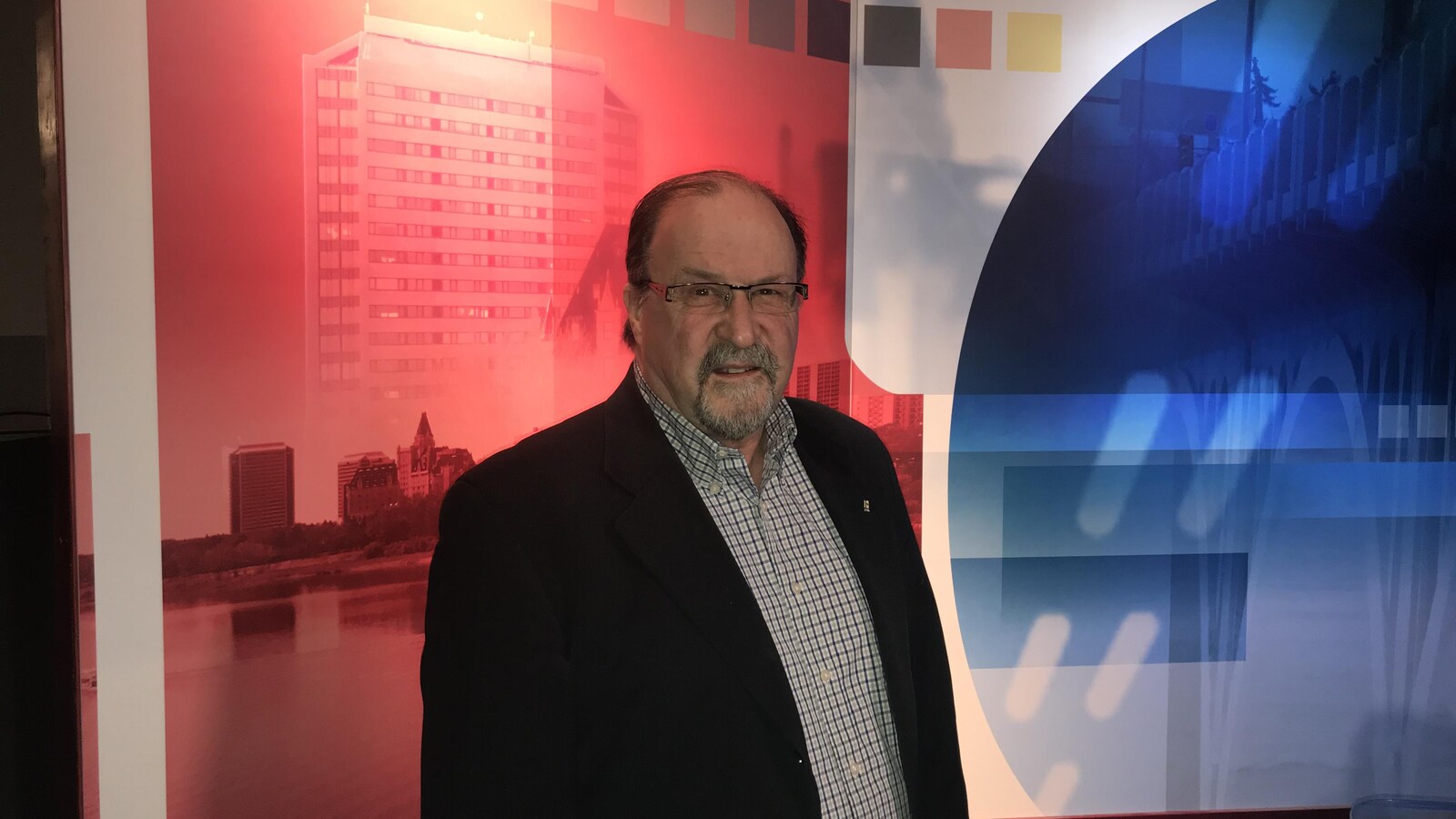 Roger Gauthier pose dans un studio de Radio-Canada.
