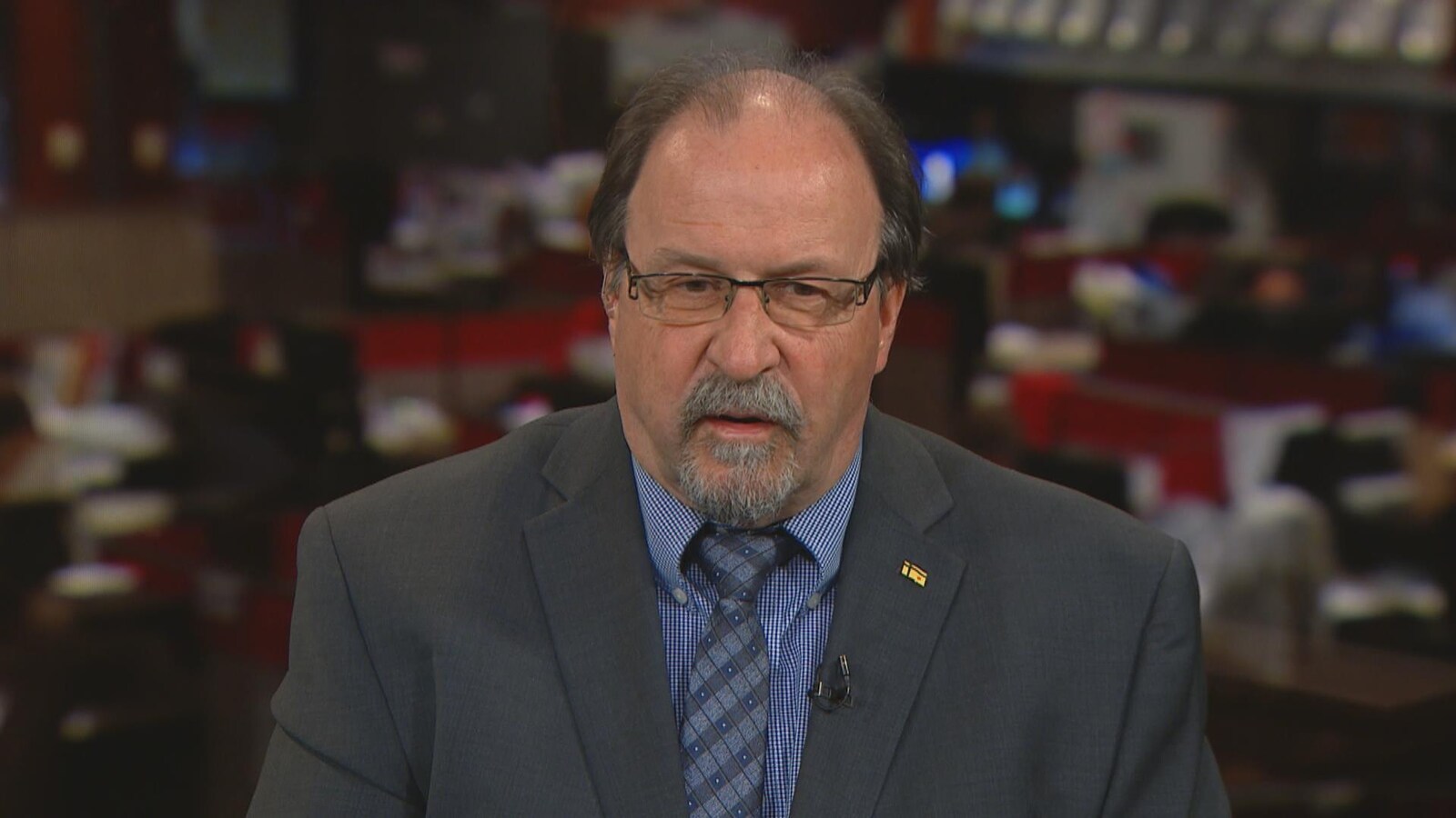 Roger Gauthier parle à la caméra depuis un studio.
