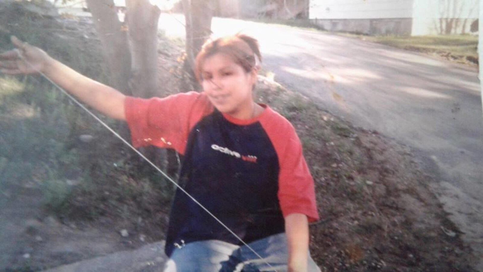 Une jeune fille souriante aux cheveux bruns avec une queue de cheval