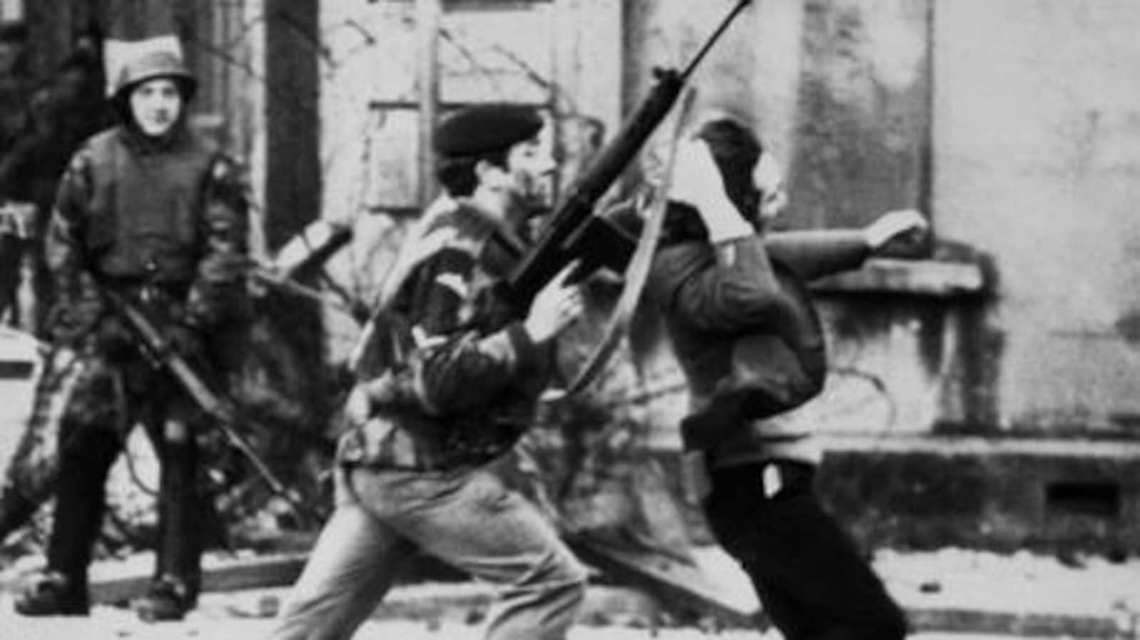 Un soldat empoigne un manifestant par les cheveux et le pousse vers l'avant.