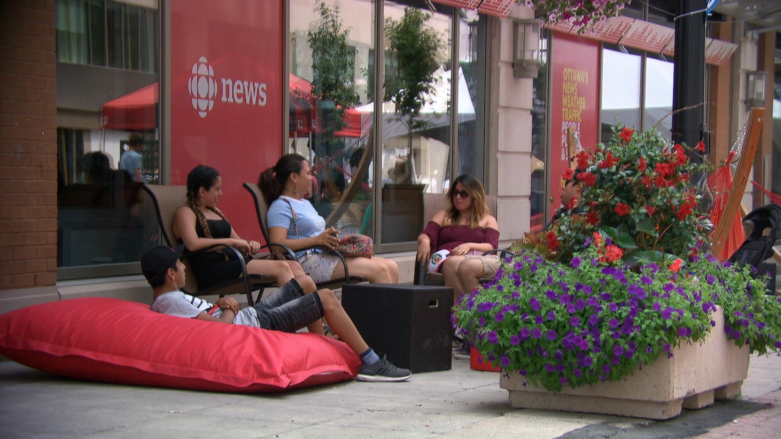 Des gens sont assis sur des chaises et des coussins sur la rue Sparks.
