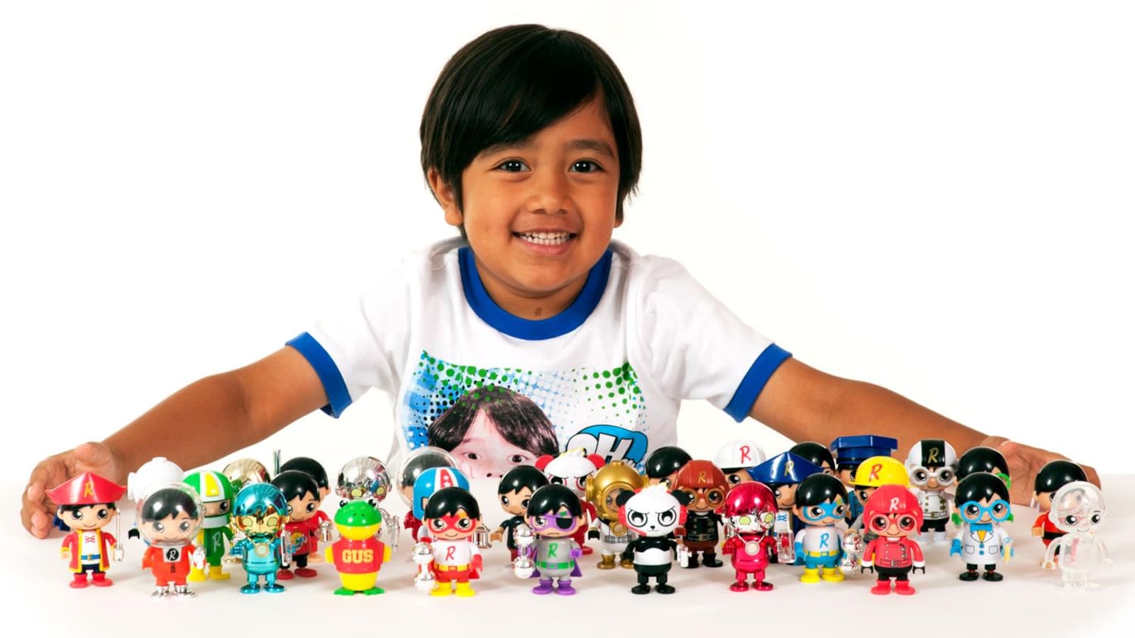 Une photo montrant Ryan derrière une trentaine de figurines colorées posées sur une table.