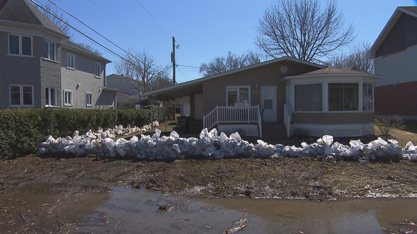 Maison à Nicolet avec des sacs de sable devant le terrain