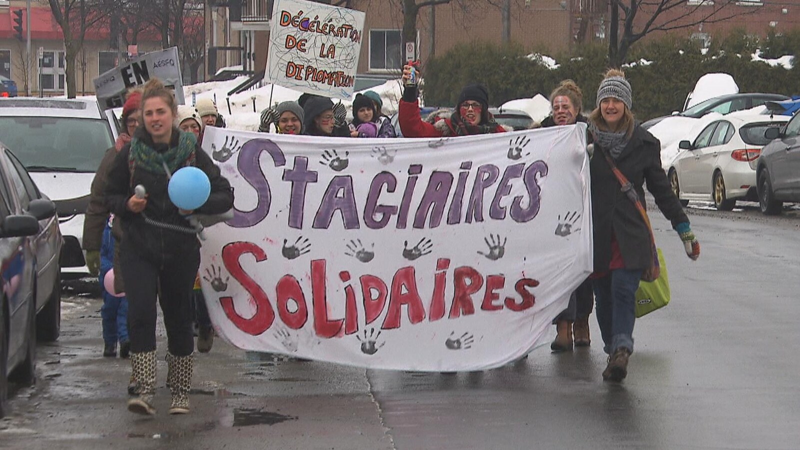 Des étudiantes tiennent une banderole où on peut lire « stagiaires solidaires ».