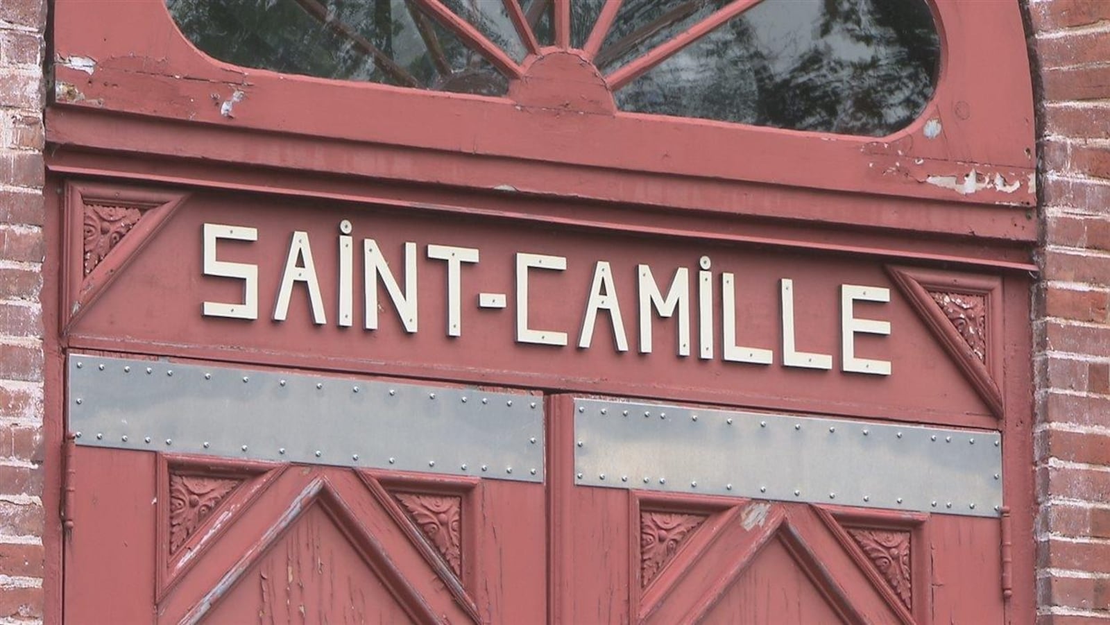 Le village de Saint-Camille est illustré par une inscription du nom du village qui figure au-dessus d'une imposante porte.