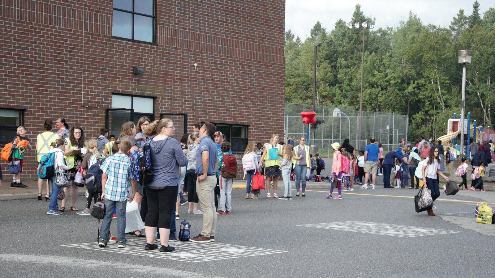 Des dizaines d'élèves jouent dans la cour de l'école