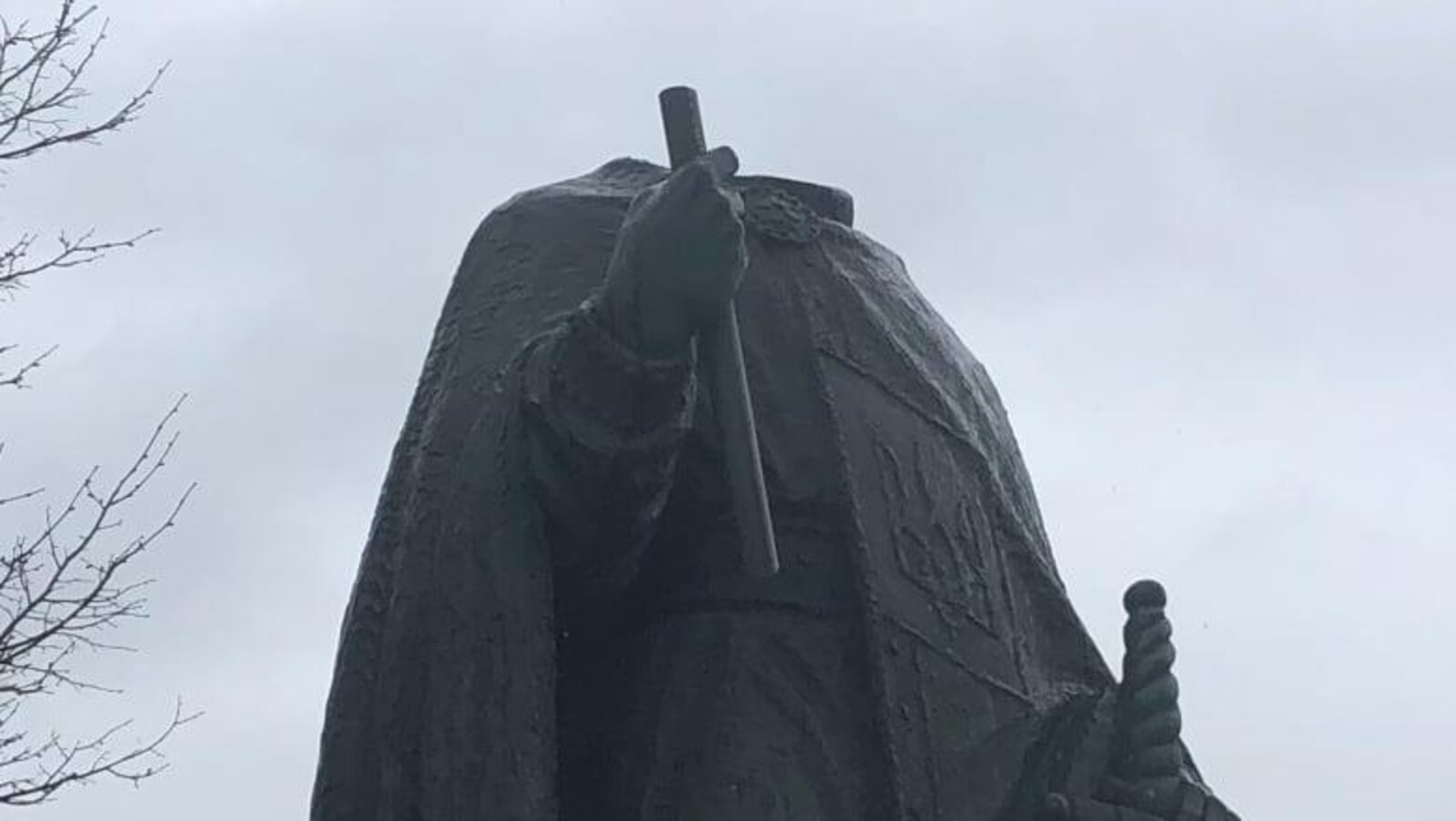 Une statue sans tête avec un ciel nuageux