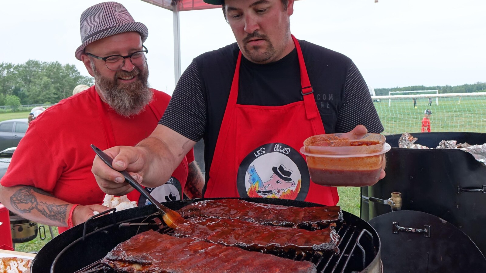 Une homme et son père font cuire de la viande