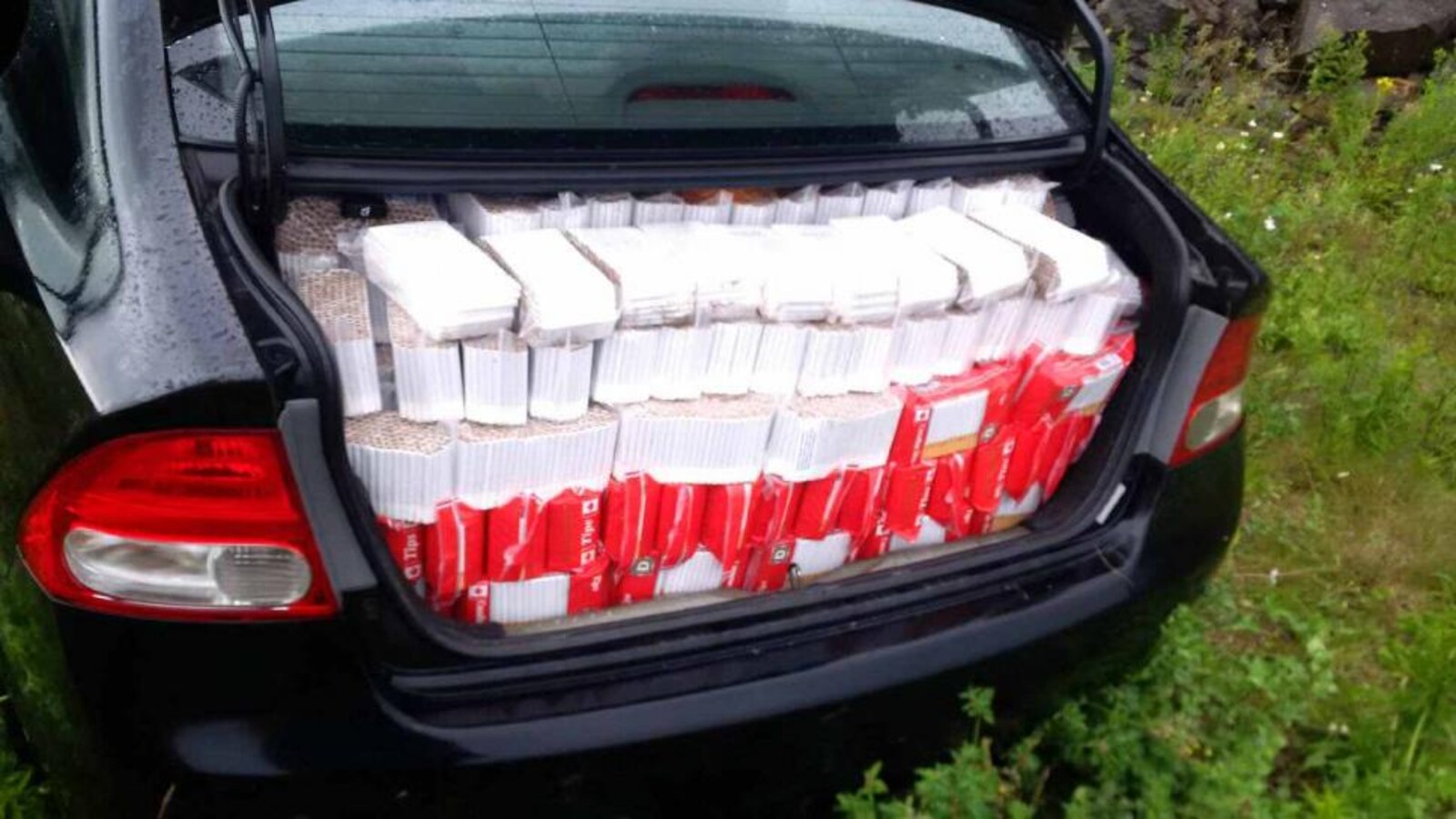 Un coffre de voiture rempli de cigarettes.