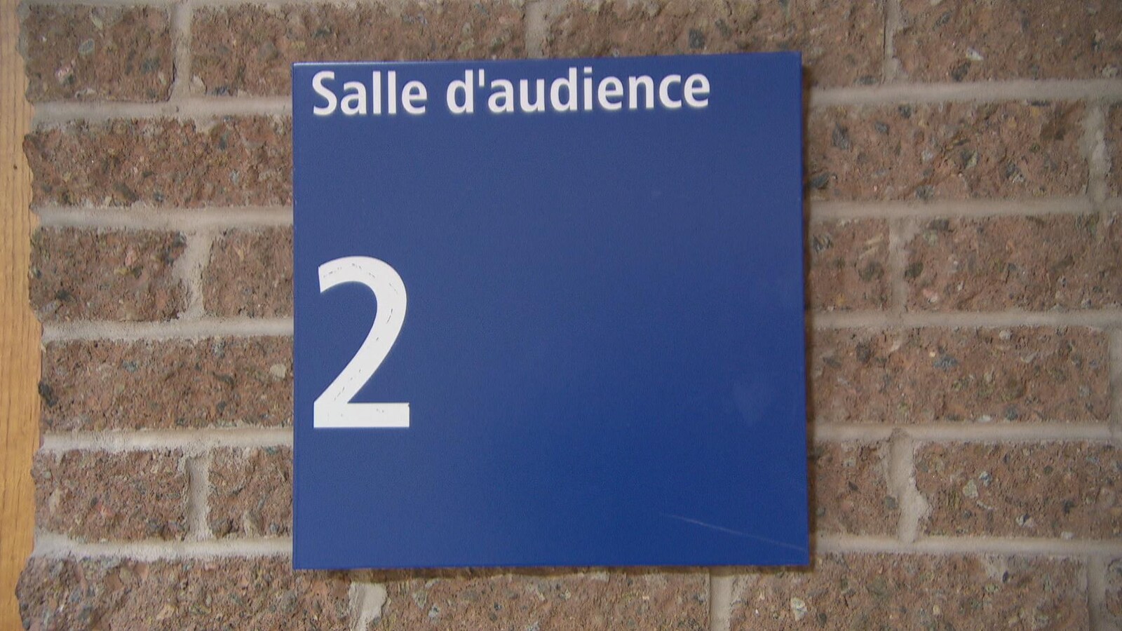 Une affiche indique la présence de la salle d'audience 2.