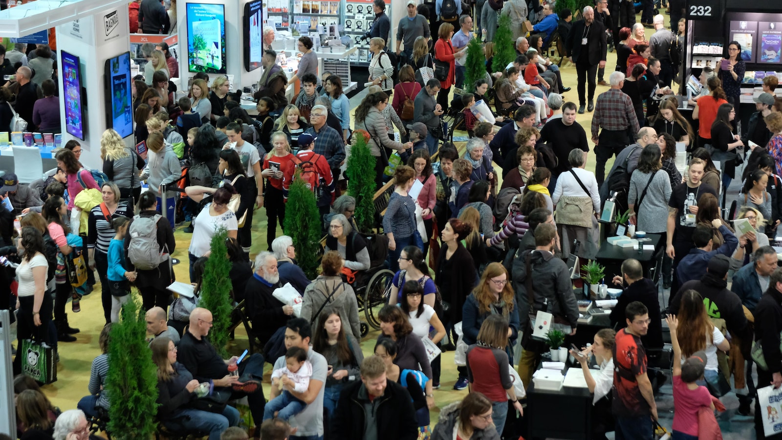 De nombreuses personnes se promènent dans les allées du Salon du livre de Montréal.