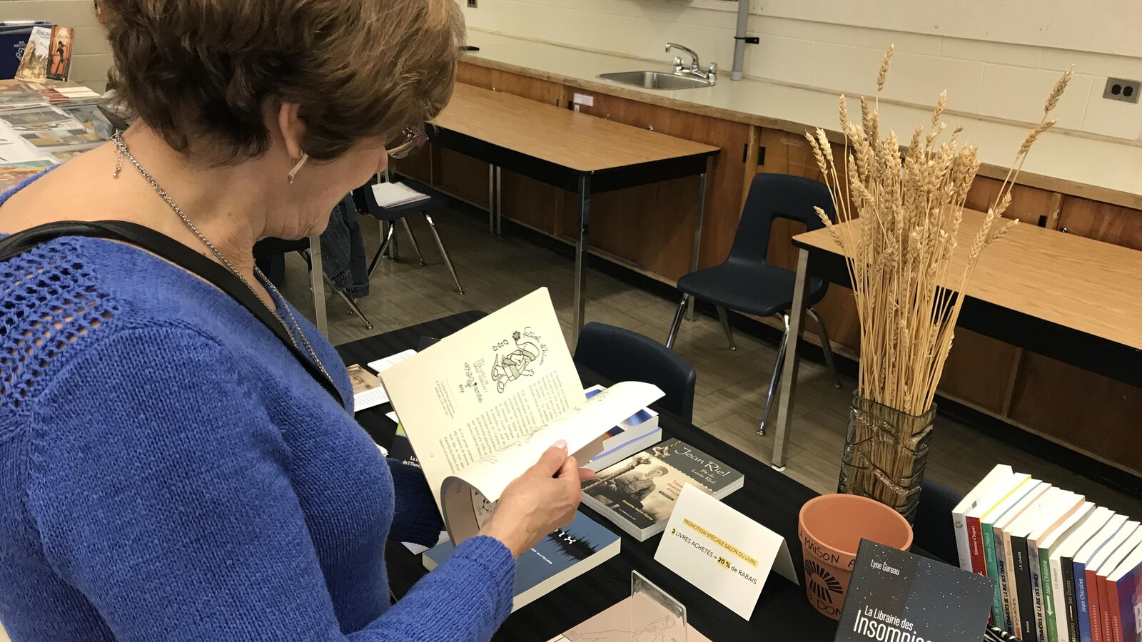 Les livres de l'édition du blé sur la table. Une femme passe à travers les pages d'un livre.