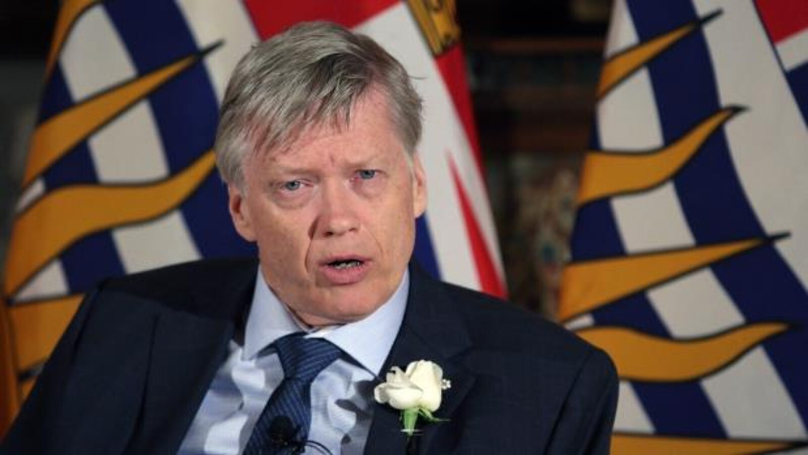 Sam Sullivan devant les drapeaux de la Colombie-Britannique