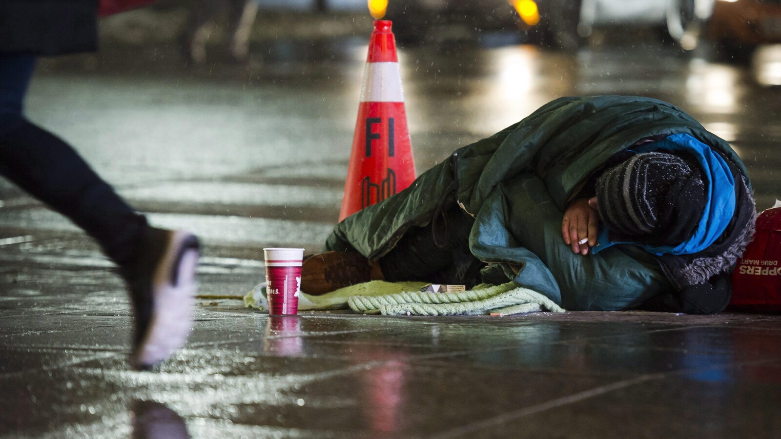 Un sans-abri couché sur le trottoir.
