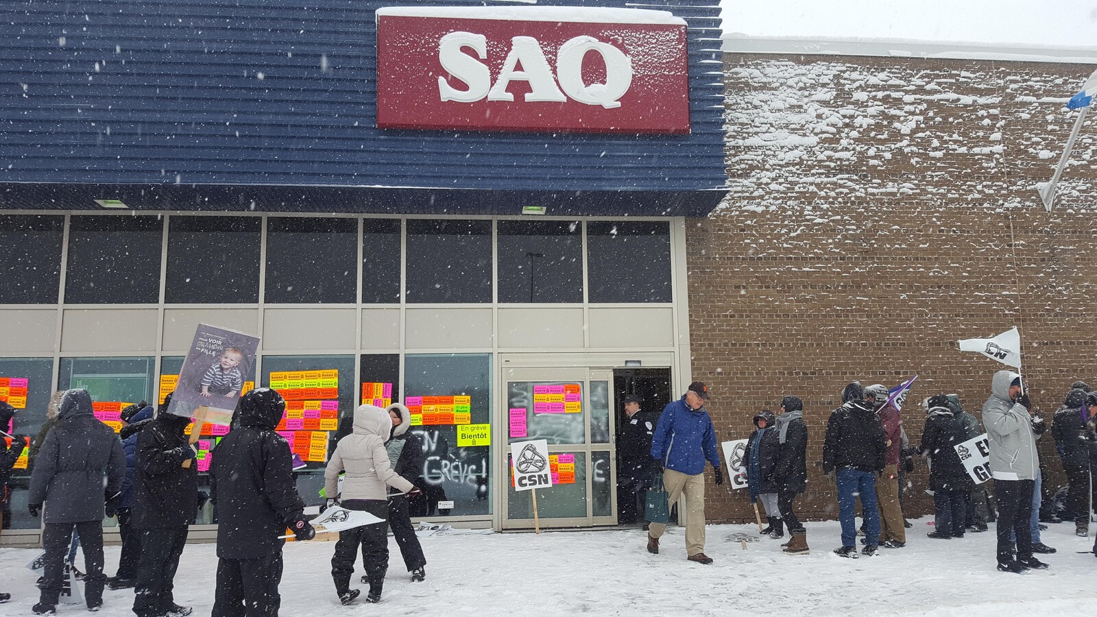 Des employés font du piquetage devant la succursale SAQ de Charlesbourg.