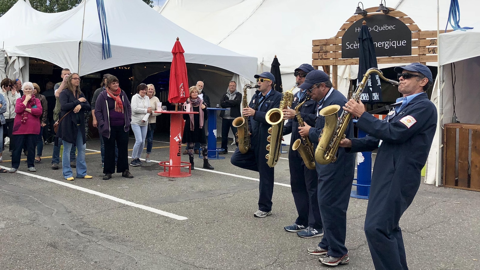 Saxophonistes dans la rue avec public.