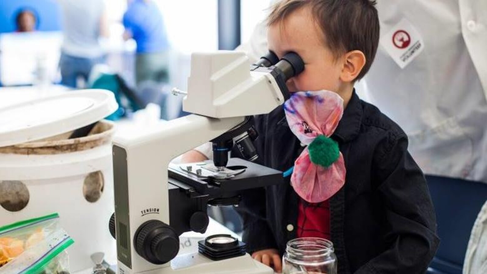 Un jeune enfant regarde dans un microscope.
